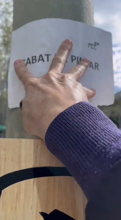 Hand stellt ein Schild «Acabat de pintar» an ein frisch gemaltes Werk, Barcelona, Art Is Trash