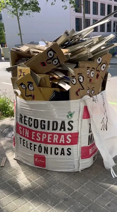 Bauschuttsack auf der Straße, gefüllt mit bemalten Kartongesichtern, Barcelona, Art Is Trash
