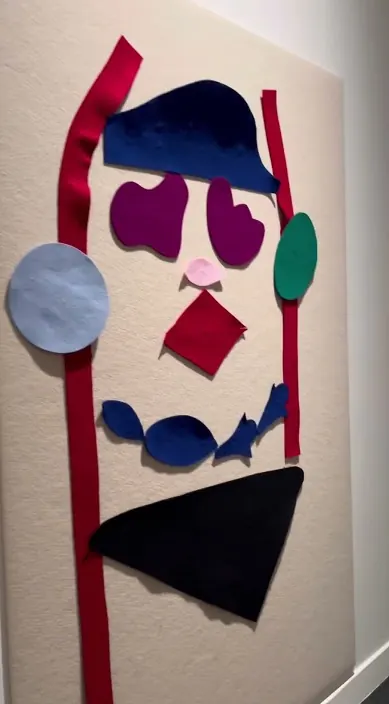 Gesicht aus bunten Stoffstücken auf einer weißen Tafel, Barcelona, Art Is Trash