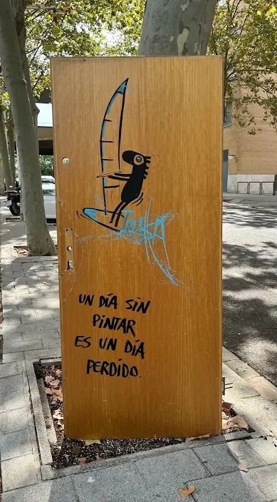 Holztür mit gemalter Figur und dem Satz „Ein Tag ohne Malen ist ein verlorener Tag“, Barcelona, Art Is Trash