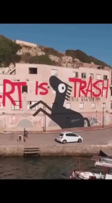 Großes Wandbild mit schwarzer Figur auf weißer Wand am Wasser, Art Is Trash